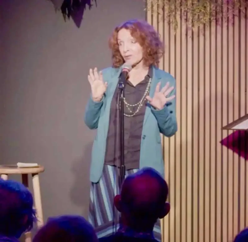 melanie chartoff onstage behind a microphone 